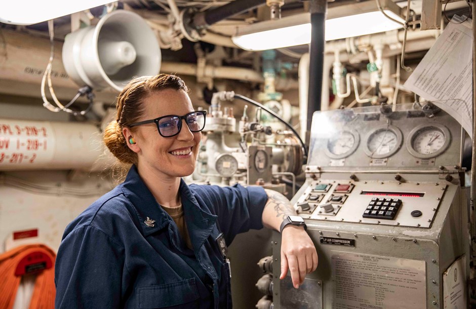 Female engineer posed by machinery